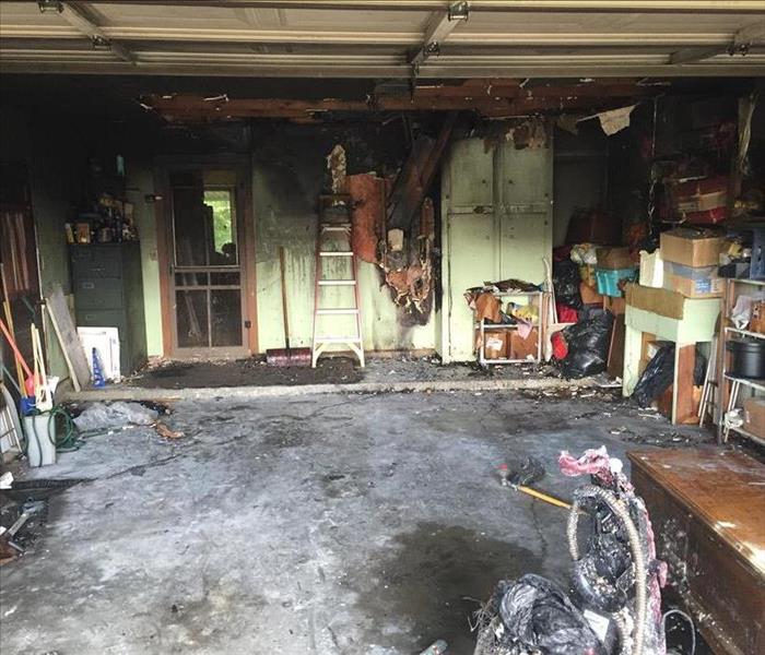 An open garage with significant fire damage and soot